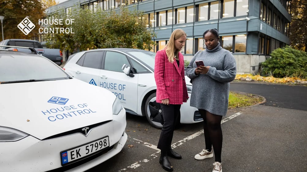 To kvinner står utenfor kontoret og ser på en mobil