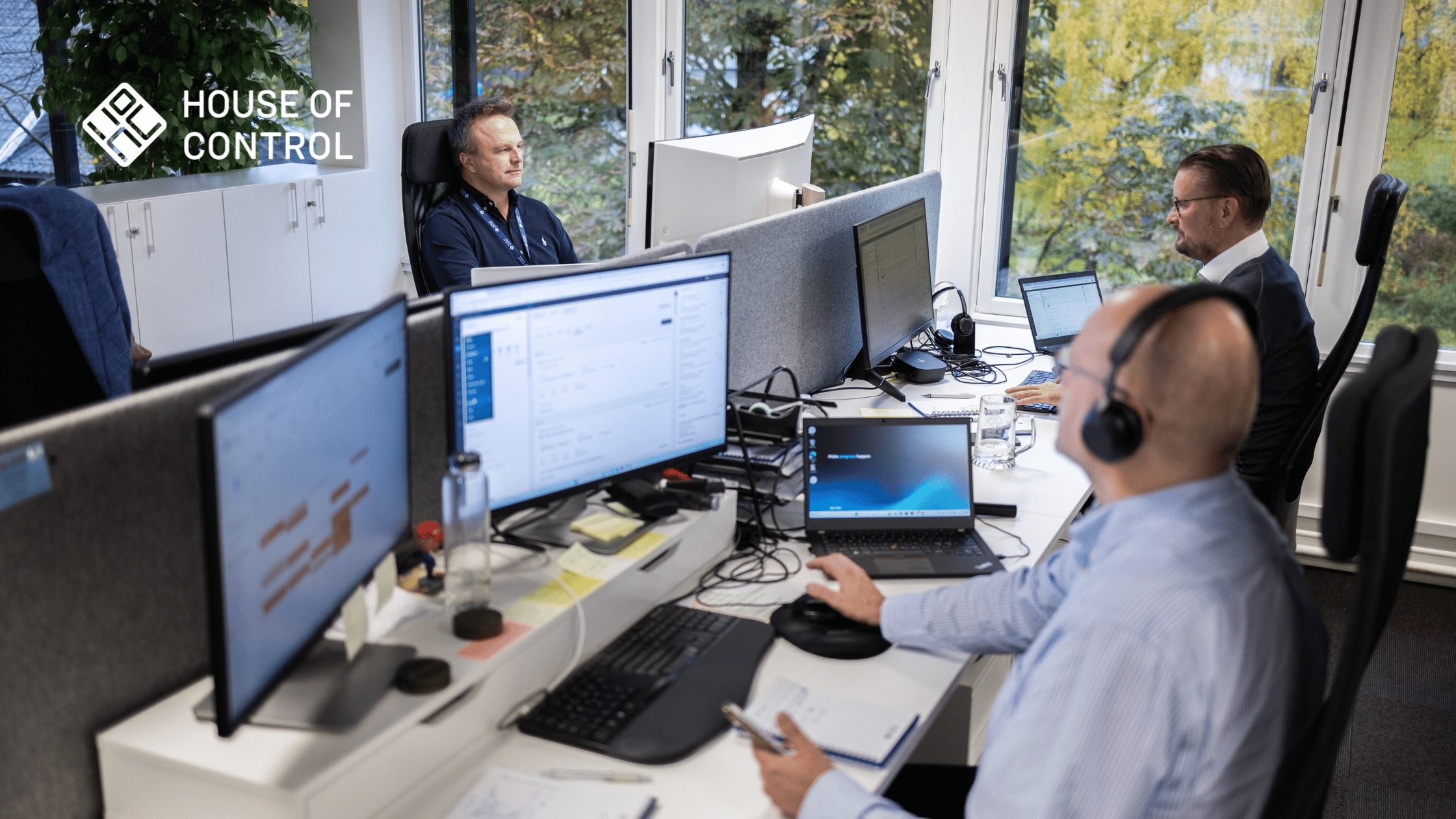 Tre män sitter framför datorerna på kontoret