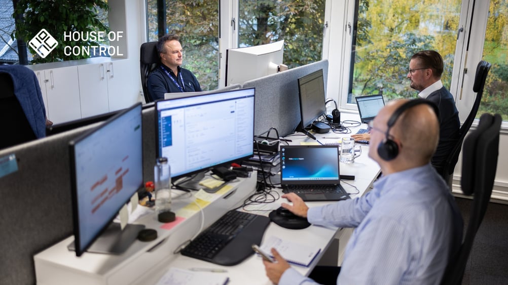 Tre menn sitter foran hver sin pc på kontoret