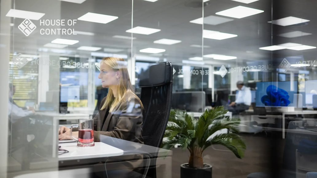 A blonde woman is working at the office in front of her computer