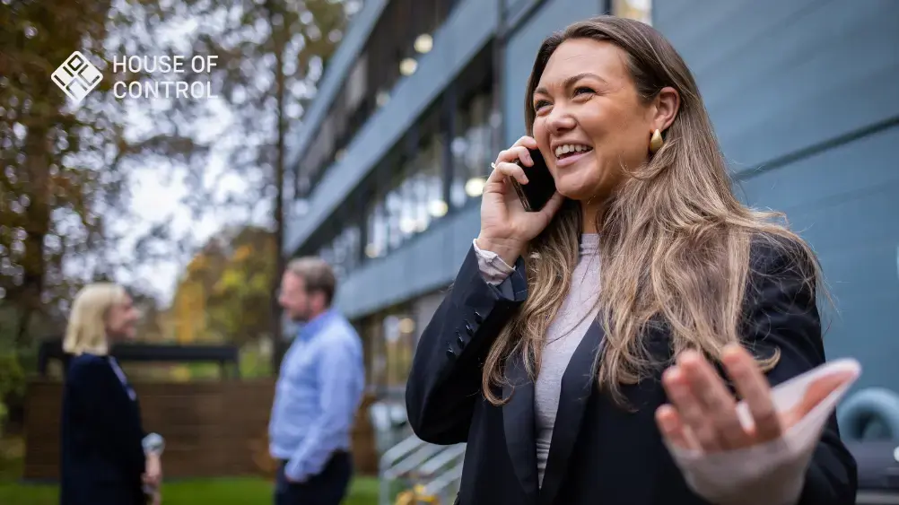Dame står utendørs og snakker i telefonen