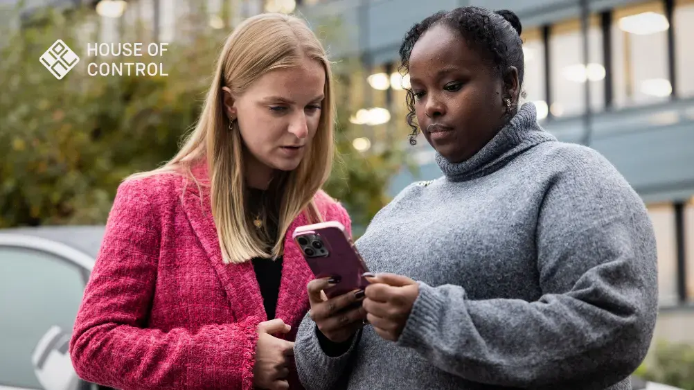 To kvinner ser på en telefon