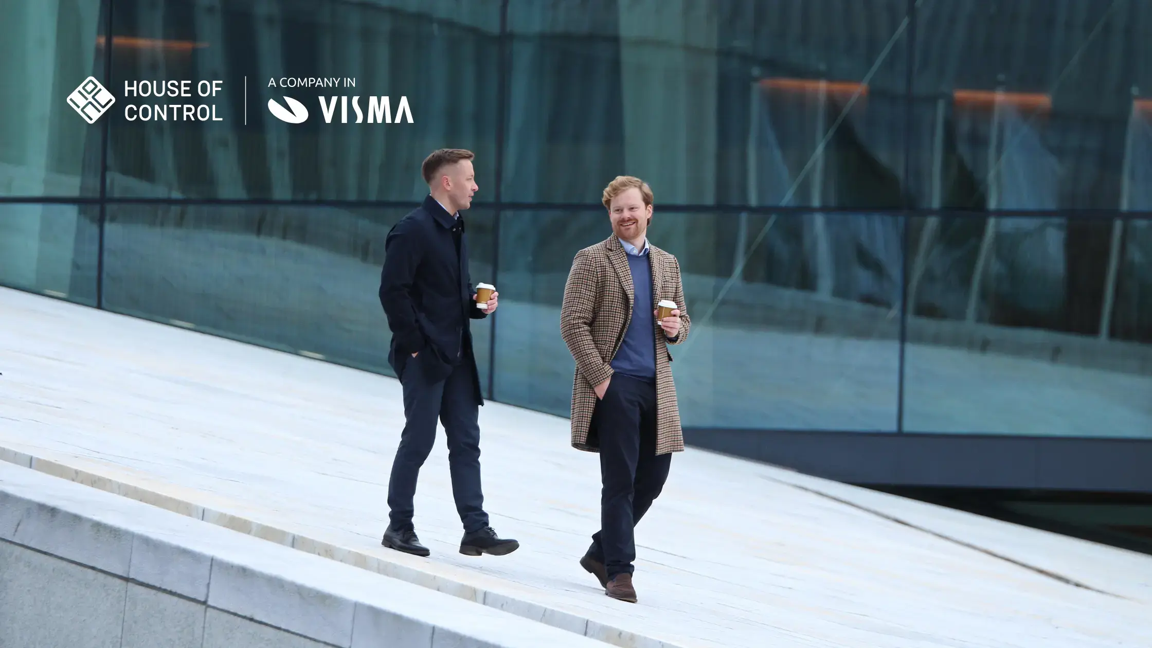 Two men walking holding coffee cups
