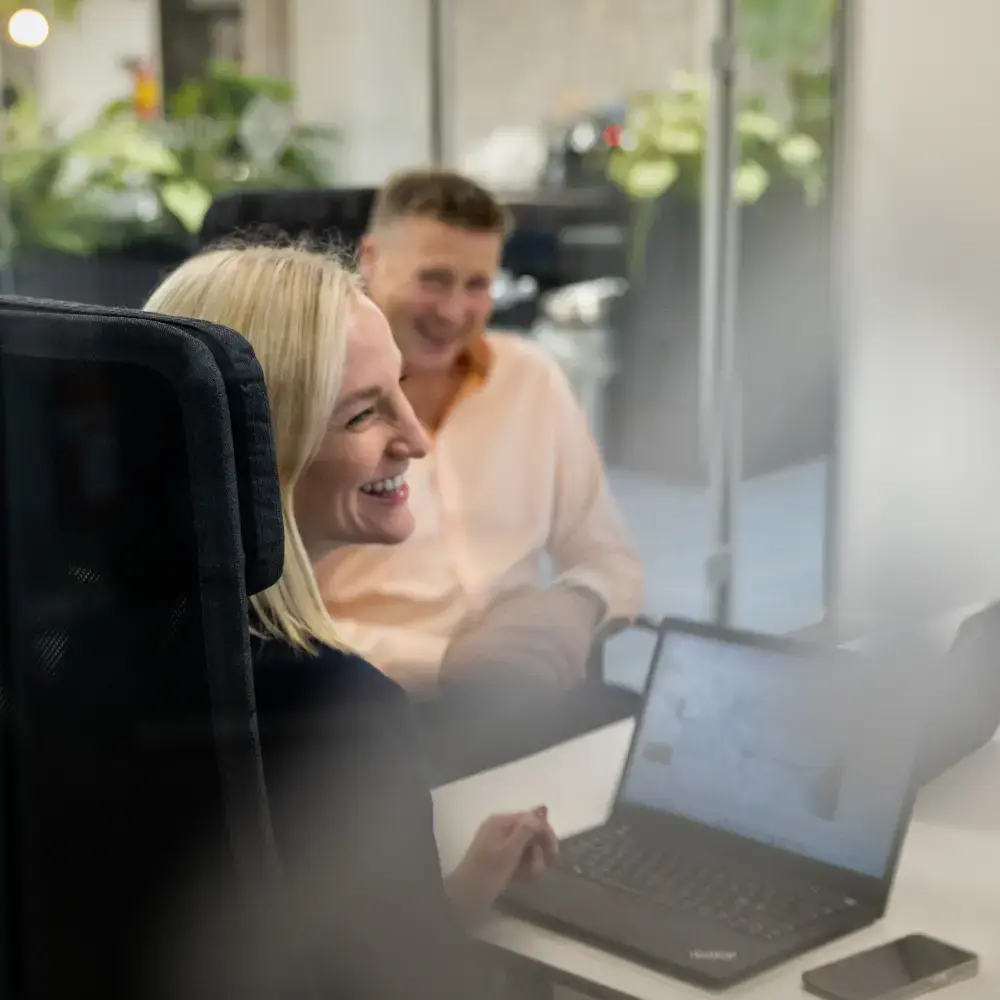 A blonde woman is smiling in a meeting at the office