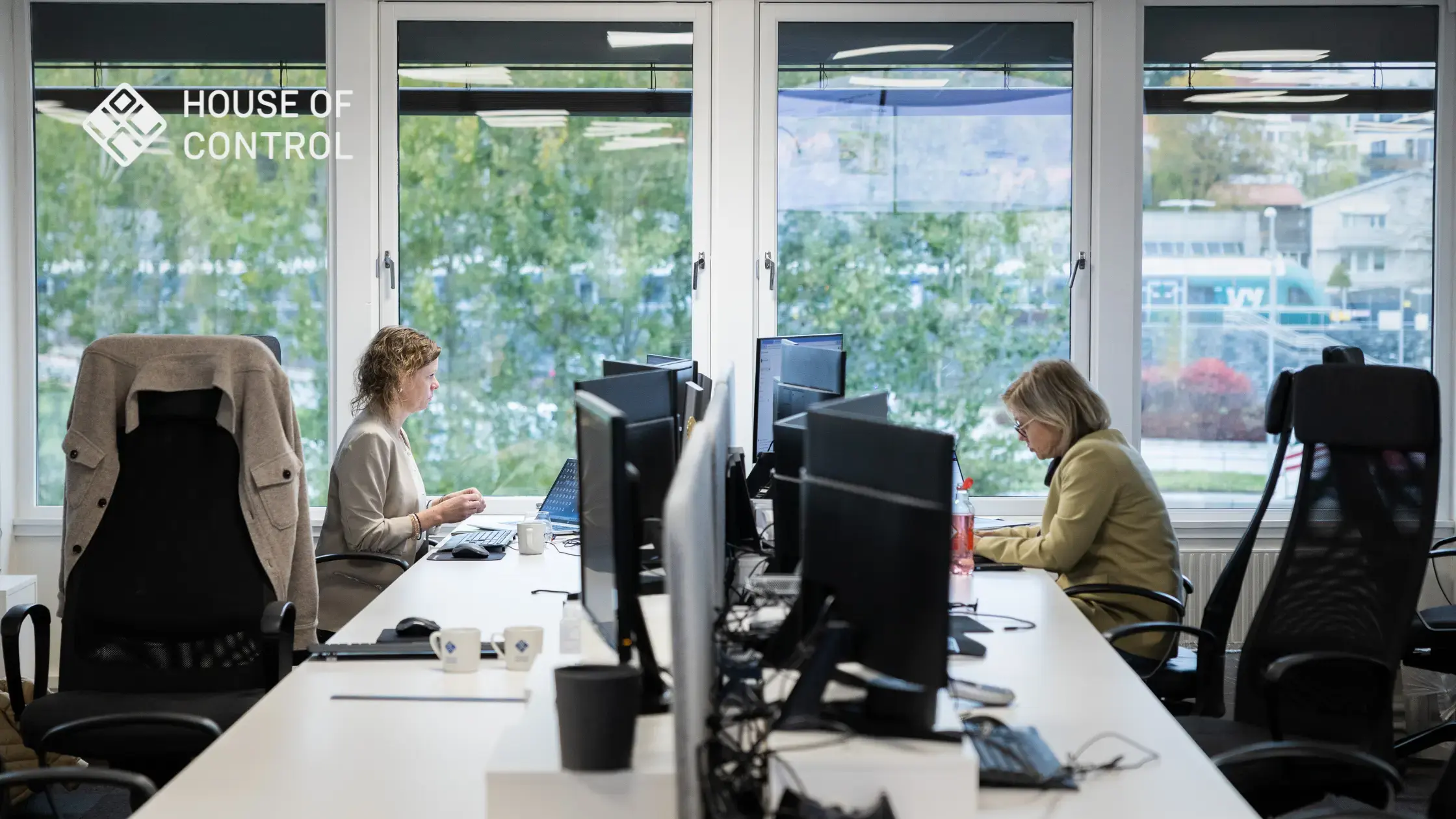 Two employees at House of Control working at their desks in an office